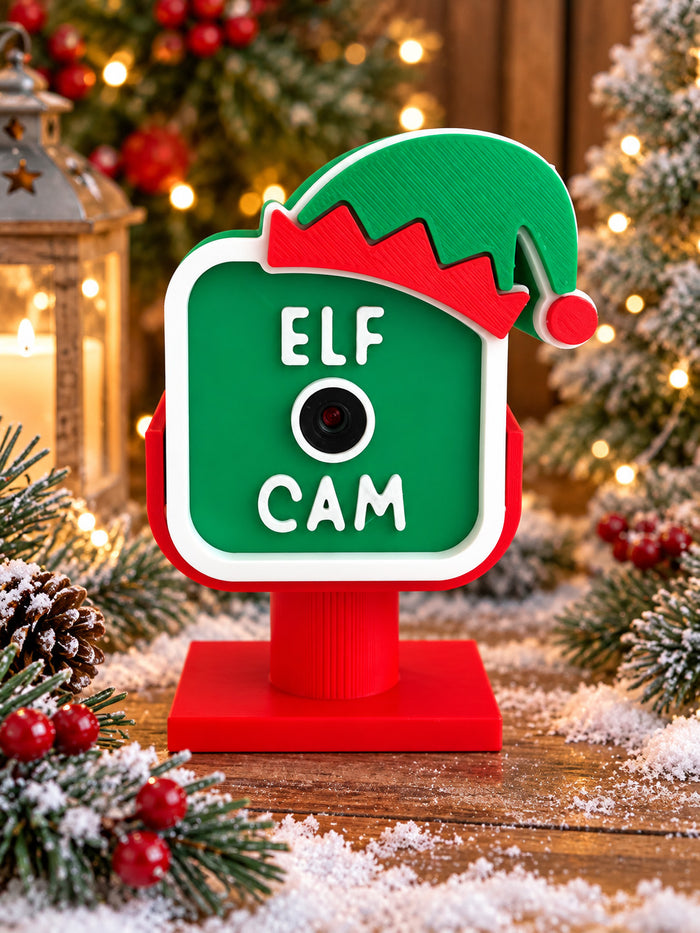 Elf Cam pretend camera decor with a pointed elf hat, zigzag cuff and pom on a square base, shown as a painted example; ships unpainted white