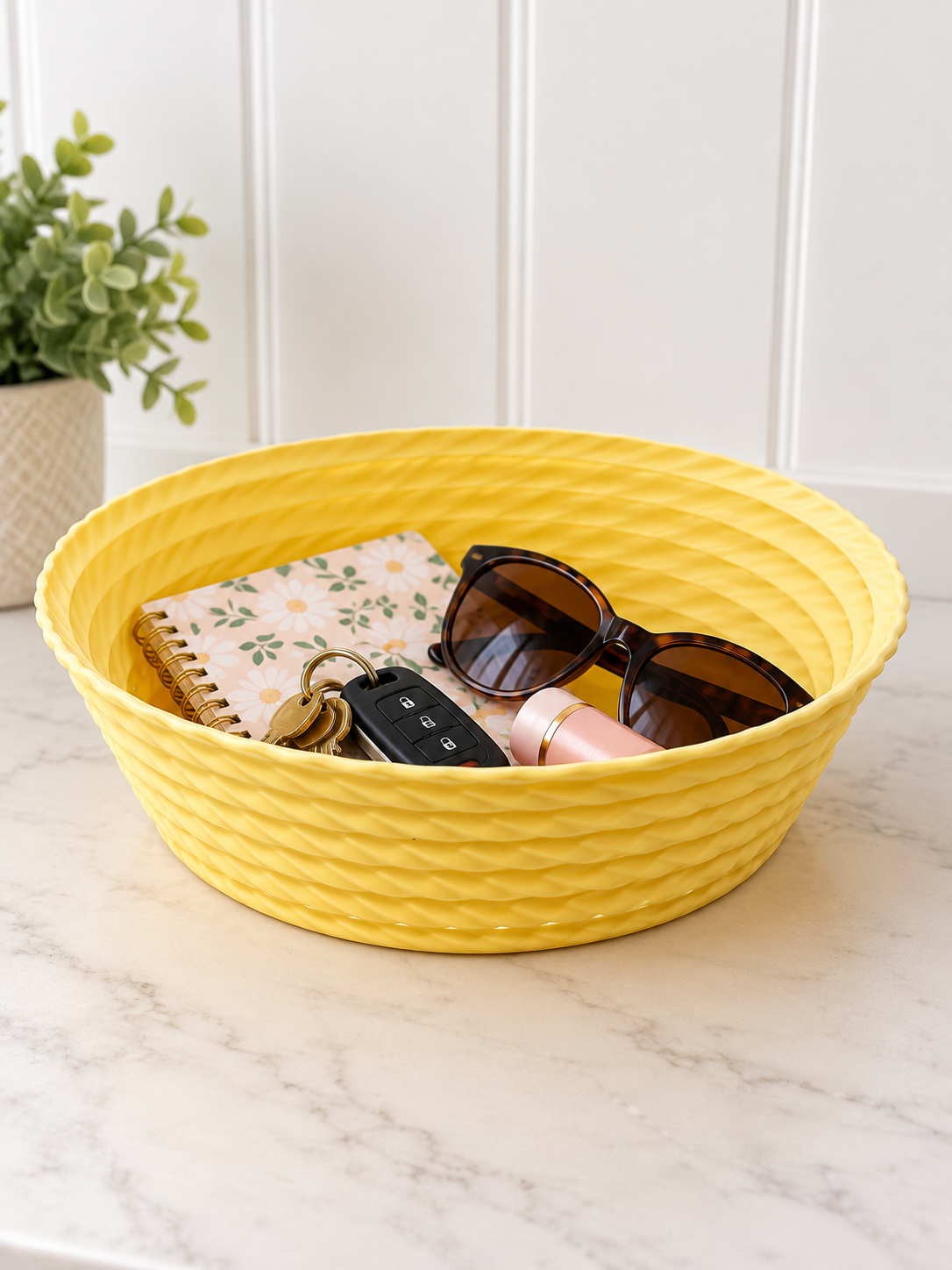 Light Yellow twisted rope catchall bowl on a marble counter, holding keys, sunglasses and a small notebook