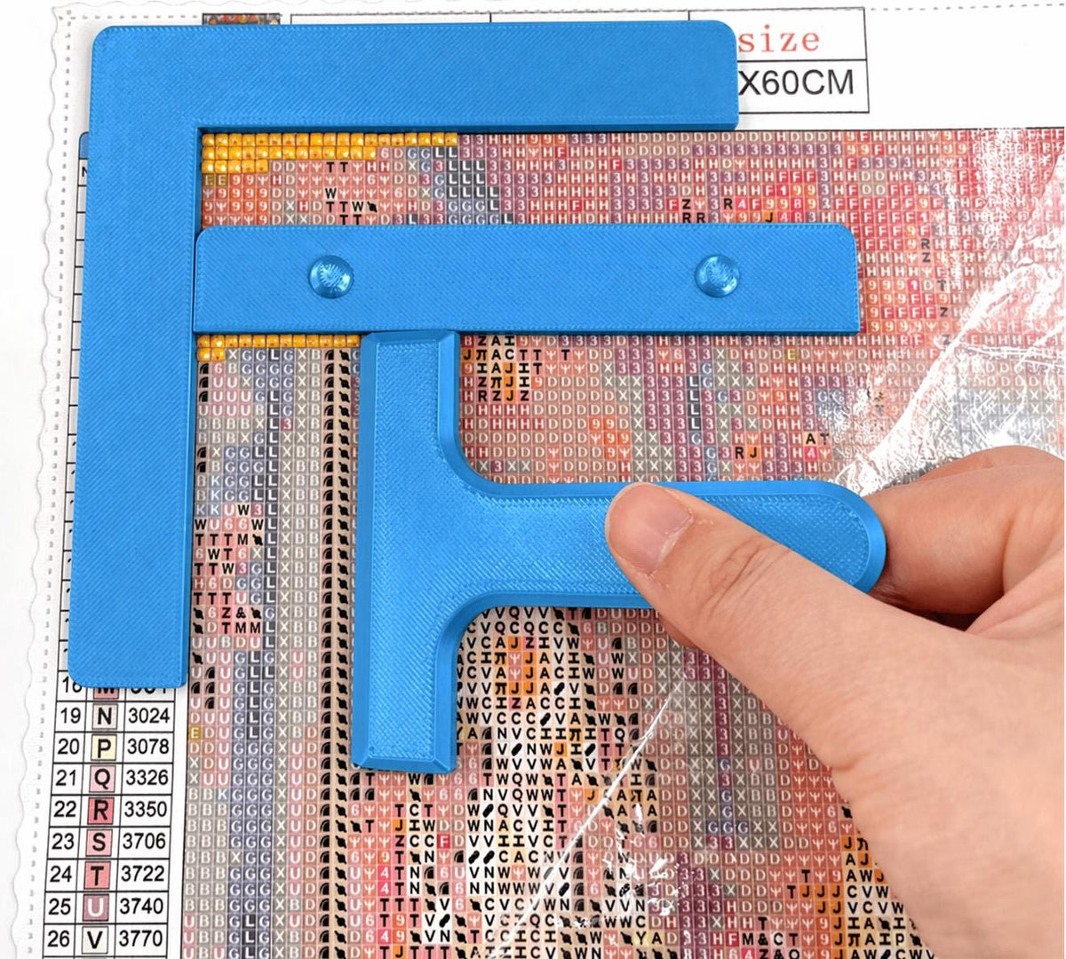Blue three-piece diamond painting tool set: right-angle ruler, straight ruler and T drill straightener on a canvas
