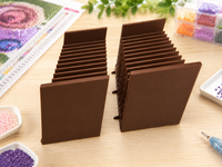Pair of coffee brown 3D printed 12-slot tilted drill packet trays on a craft table – image 9