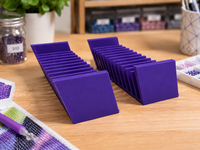 Pair of purple 3D printed 12-slot tilted drill packet trays on a craft table – image 7