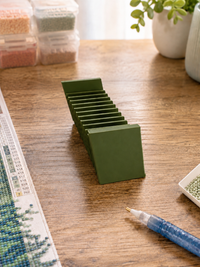 Olive green 3D printed 12-slot tilted drill packet tray on a wooden craft table – image 8