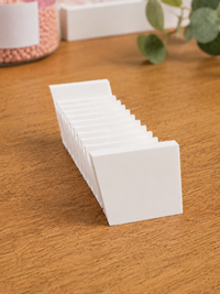 White 3D printed 12-slot tilted drill packet tray on a wooden craft table – image 1