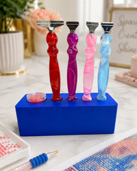Blue Drill Pen Station holding four resin drill pens, with wax in the wax well, on a craft table – image 13