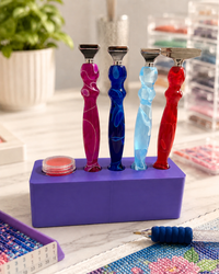 Purple Drill Pen Station holding four resin drill pens, with wax in the wax well, on a craft table – image 3