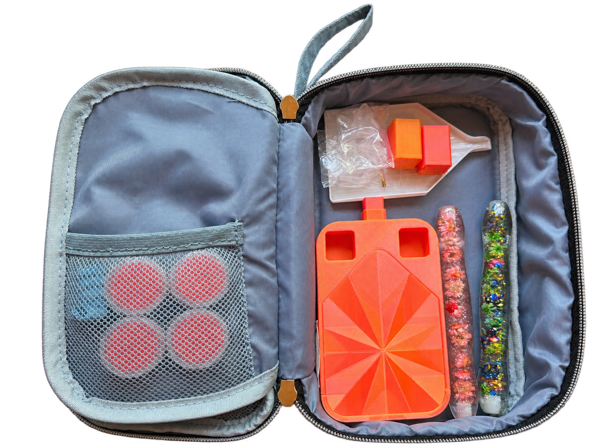 The Tool Keeper in slate blue, packed with an orange drill tray, two drill pens and round wax refills in the mesh pocket